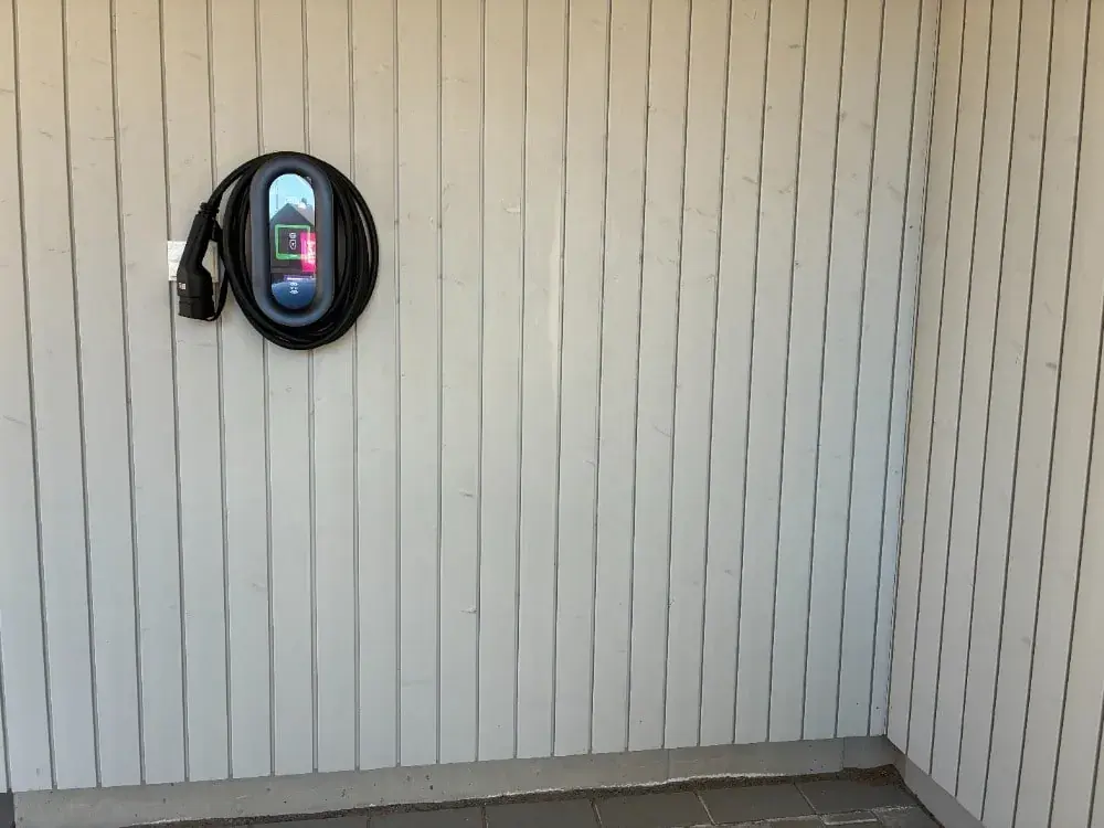 sähköautonlatauspiste omakotitalon autotallin seinässä