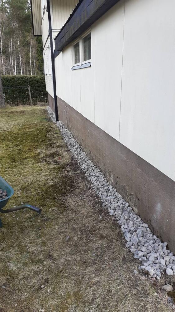 Sokkelin siistiminen ja kivetyksen asennus talon ympärille