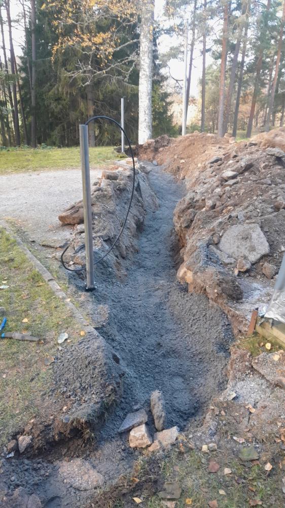 Kaapelin kaivuuta lämmitystolpalle